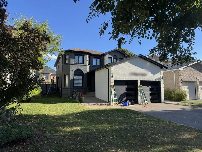 The same house on installation day, ladders against the garage