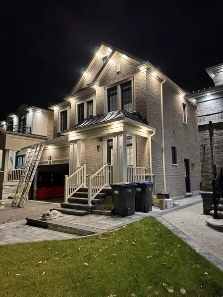 New brick home with exterior soffit potlights at night