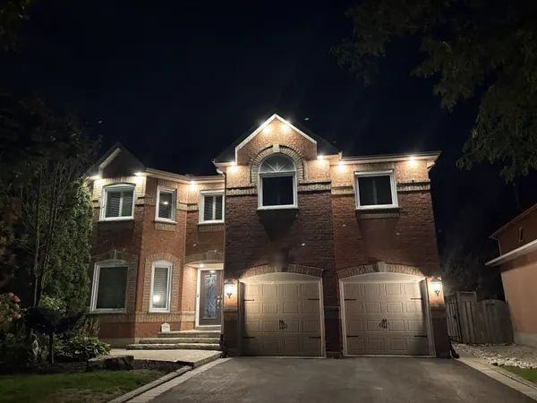 Two-storey brick home with soffit potlights above the garage