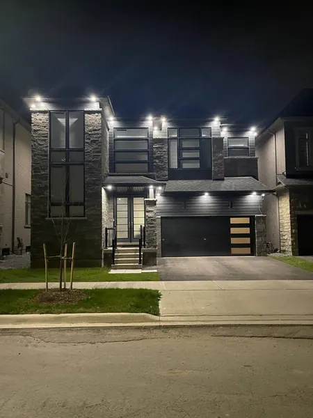 Modern home with potlights across the facade at night