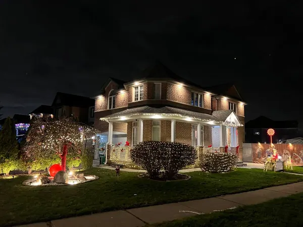Home with warm exterior potlights and porch lighting at night