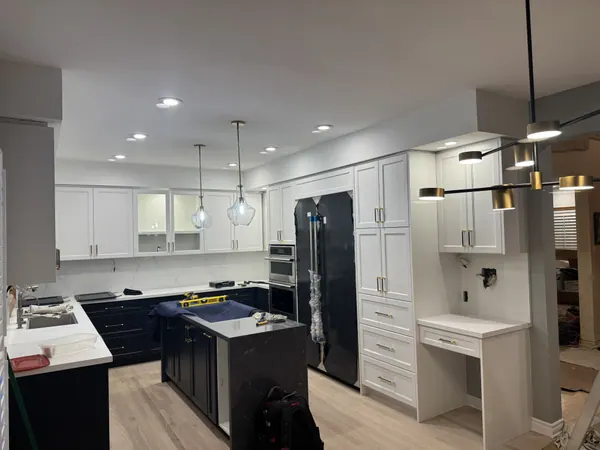 White kitchen with potlights, glass pendants and wall sconces