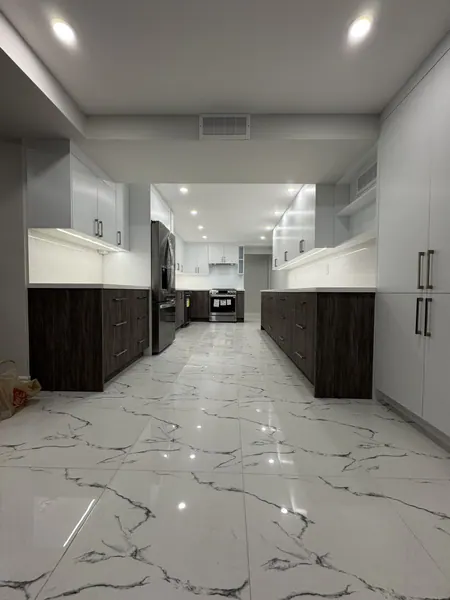 Long kitchen with rows of potlights and LED cabinet lighting